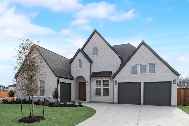 french country style house featuring a garage and a front lawn