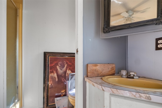 bathroom with toilet, ceiling fan, and sink