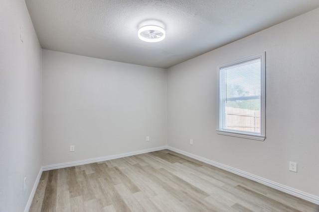 empty room featuring light hardwood / wood-style flooring and a textured ceiling