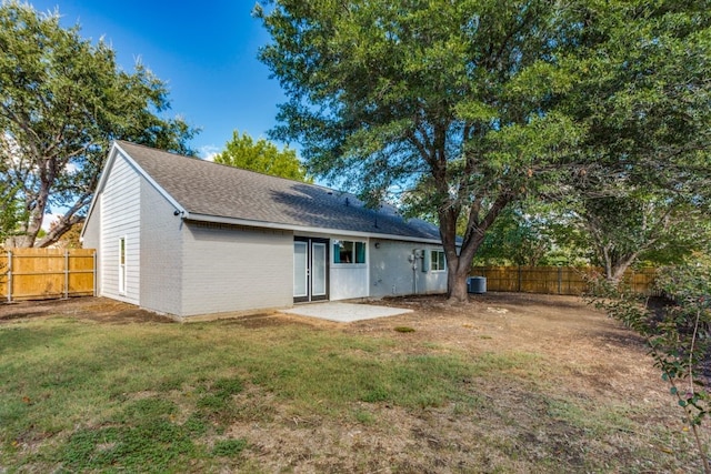 rear view of property featuring a lawn, a patio area, and cooling unit