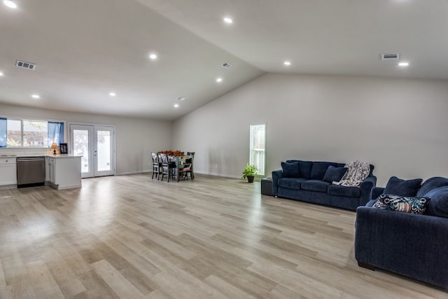 living room featuring light hardwood / wood-style flooring, high vaulted ceiling, and french doors