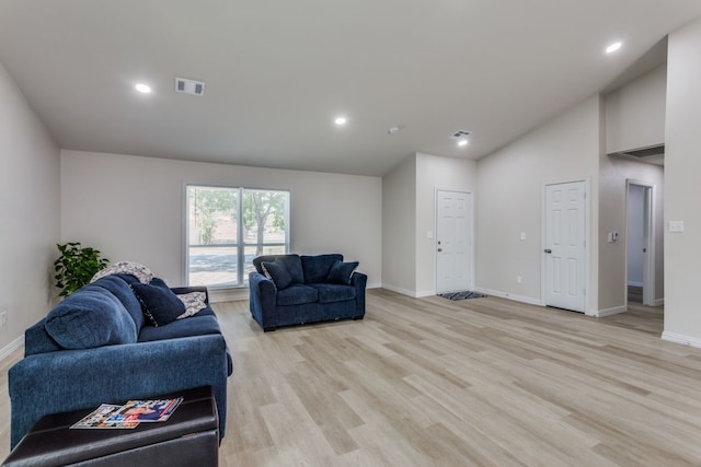 living room with light hardwood / wood-style flooring and high vaulted ceiling