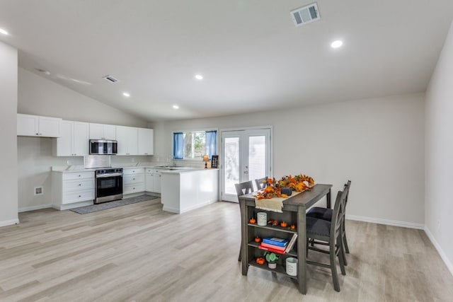 kitchen featuring light hardwood / wood-style flooring, white cabinets, stainless steel appliances, and vaulted ceiling