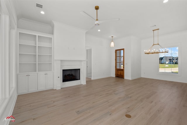 unfurnished living room featuring ornamental molding, ceiling fan with notable chandelier, and light wood-type flooring