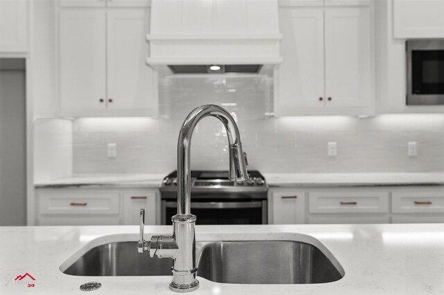 kitchen with white cabinets, decorative backsplash, and light stone countertops