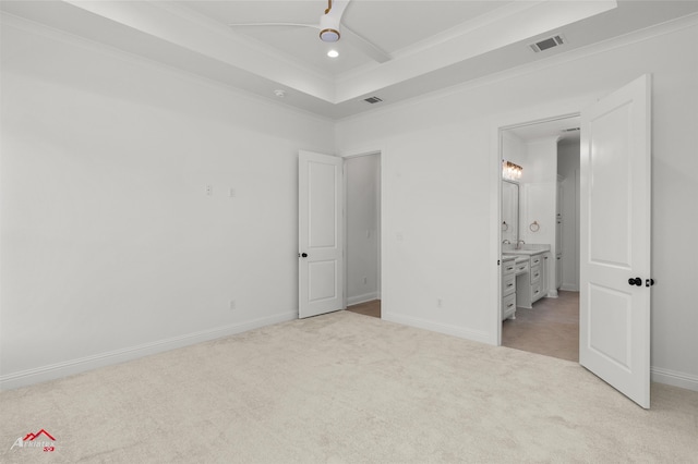 unfurnished bedroom featuring ensuite bathroom, ceiling fan, light colored carpet, and crown molding