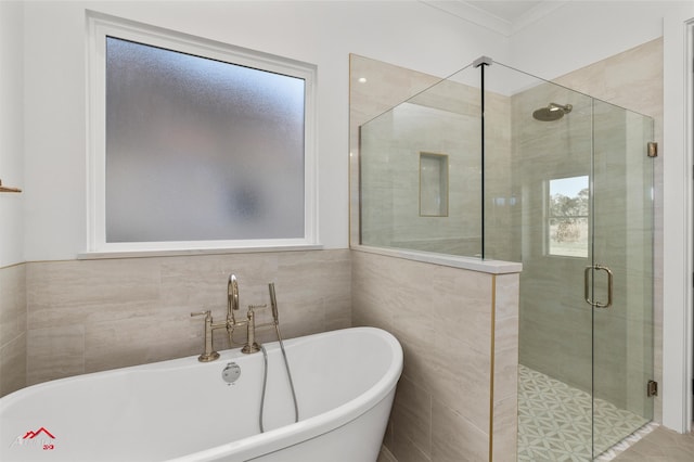 bathroom with crown molding, plus walk in shower, and tile walls