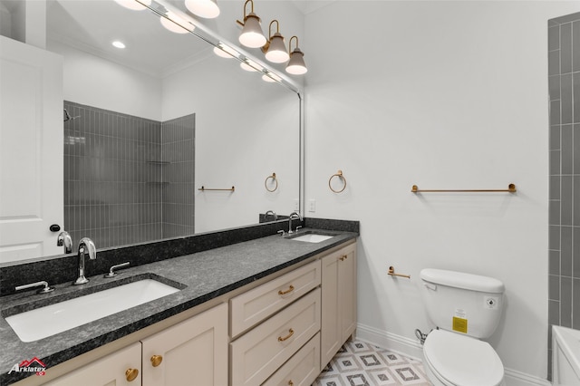 bathroom with a tile shower, vanity, and toilet