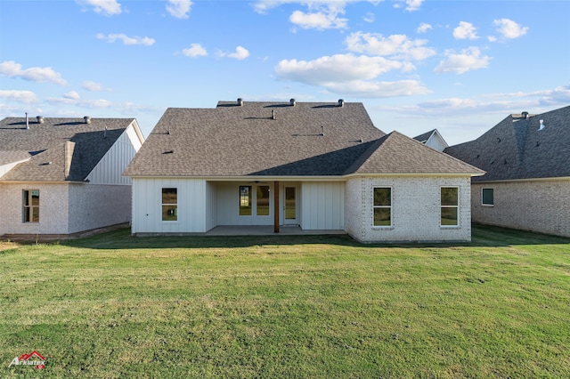 rear view of property featuring a lawn and a patio area