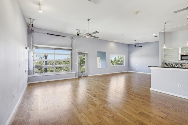 unfurnished living room featuring hardwood / wood-style flooring and ceiling fan