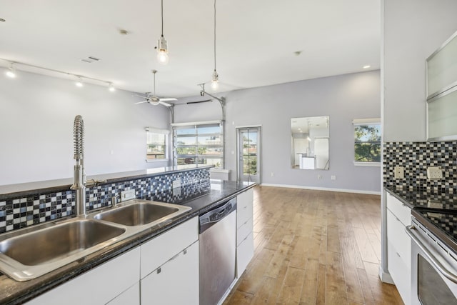 kitchen featuring backsplash, white cabinets, light hardwood / wood-style floors, and appliances with stainless steel finishes