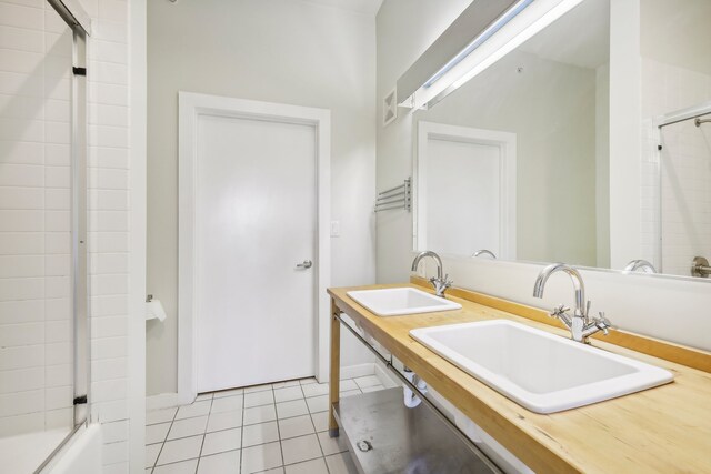 bathroom featuring tile patterned floors, vanity, and combined bath / shower with glass door