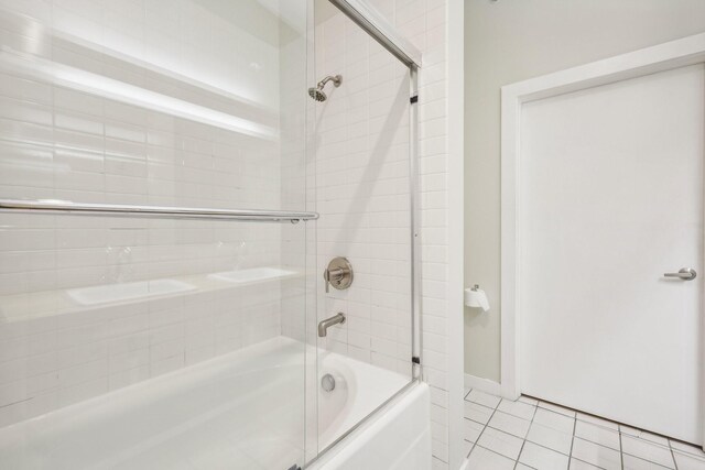 bathroom with tile patterned flooring and bath / shower combo with glass door