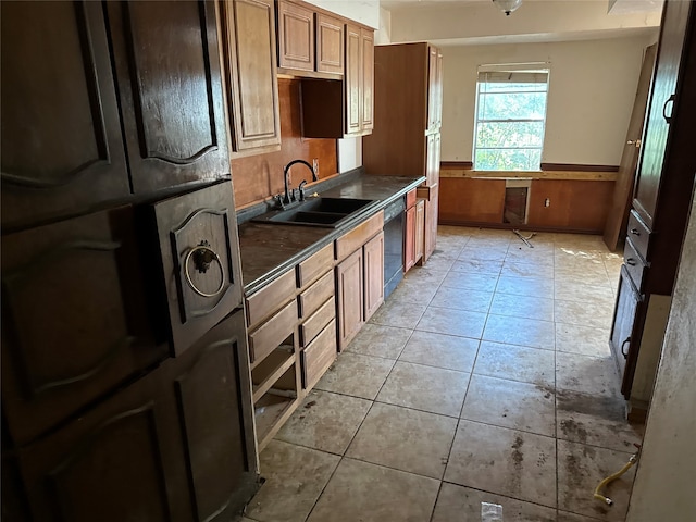 kitchen featuring sink, black dishwasher, light tile patterned floors, and refrigerator