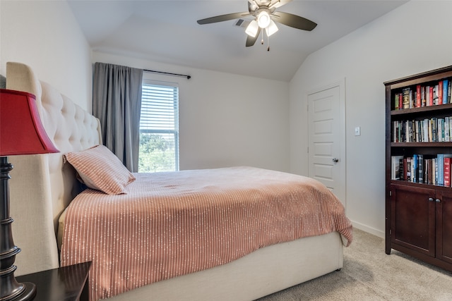 bedroom with ceiling fan, light colored carpet, and vaulted ceiling