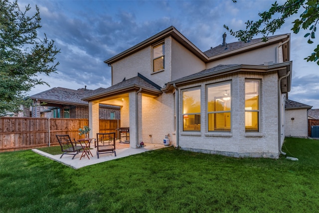 rear view of house featuring a yard, a patio area, and central air condition unit