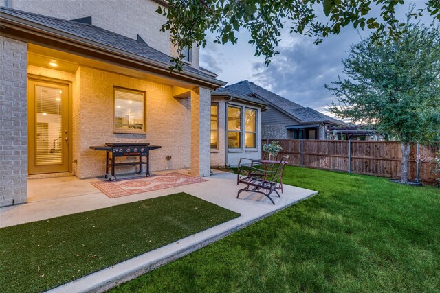 back of house with a lawn and a patio