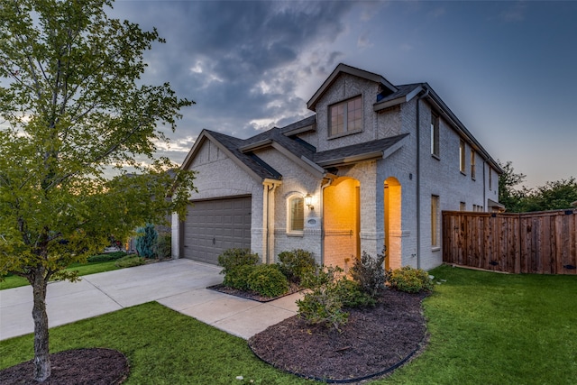 view of front of house with a garage and a lawn