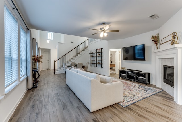 living room with a tile fireplace, hardwood / wood-style flooring, plenty of natural light, and ceiling fan