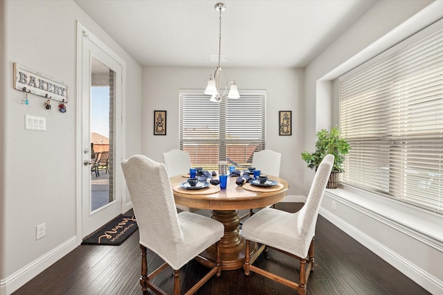 dining room featuring dark wood-type flooring, an inviting chandelier, and a healthy amount of sunlight