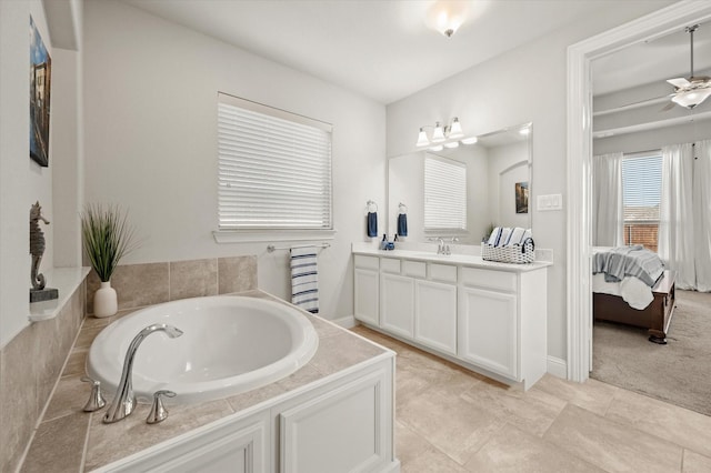 bathroom with ceiling fan, a tub to relax in, vanity, and tile patterned flooring