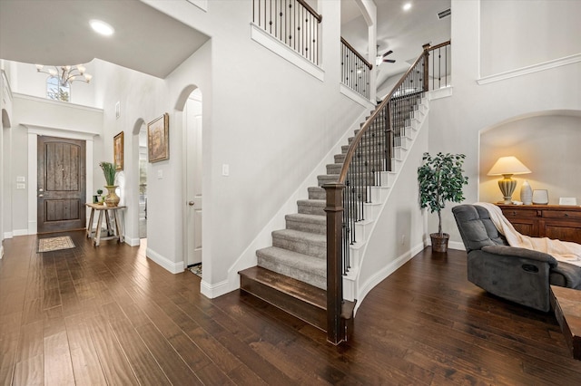 foyer featuring dark wood-type flooring, a high ceiling, and a chandelier