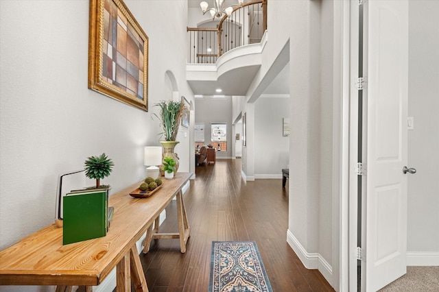 hall with dark hardwood / wood-style flooring and a chandelier