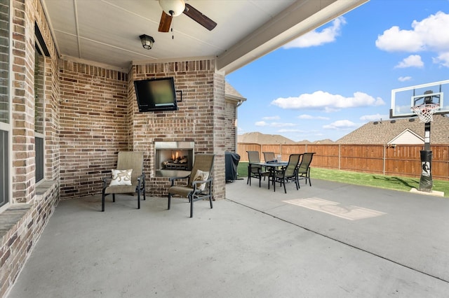 view of patio / terrace with an outdoor brick fireplace and ceiling fan