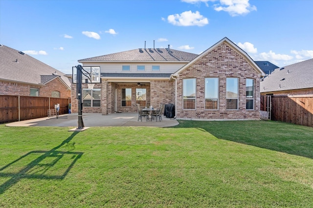 rear view of property with ceiling fan, a yard, and a patio