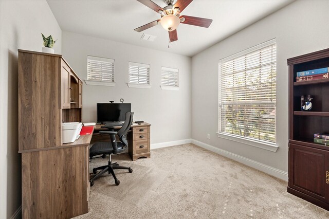 carpeted office space featuring ceiling fan