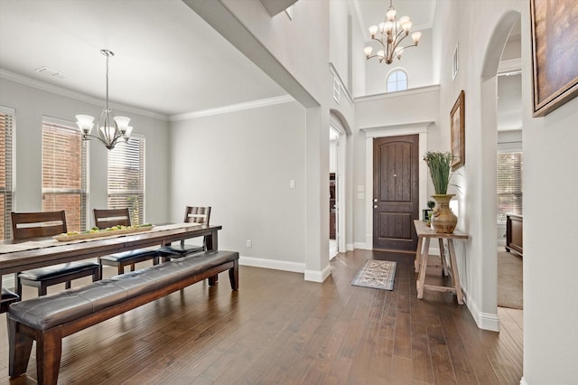 entryway featuring dark hardwood / wood-style floors, crown molding, and a chandelier