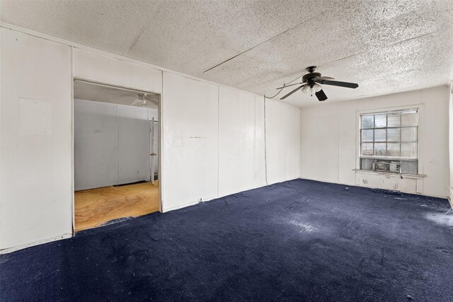 carpeted empty room featuring ceiling fan, cooling unit, and a textured ceiling