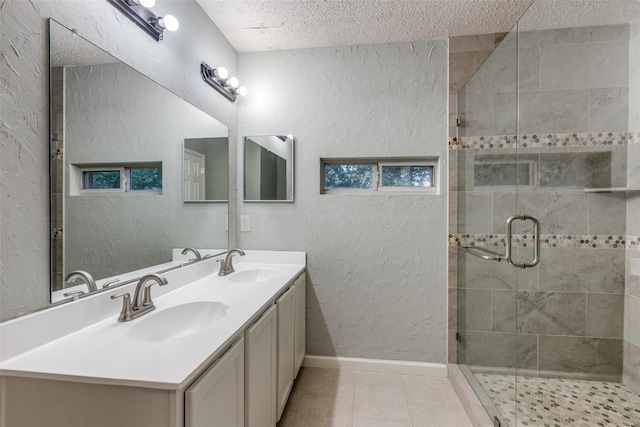 bathroom featuring tile patterned flooring, vanity, a textured ceiling, and walk in shower