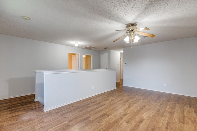 empty room featuring ceiling fan, light hardwood / wood-style flooring, and a textured ceiling