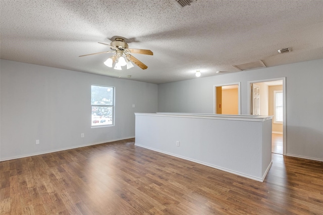 spare room with ceiling fan, dark hardwood / wood-style flooring, and a textured ceiling