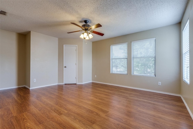 empty room featuring hardwood / wood-style floors, a textured ceiling, and ceiling fan