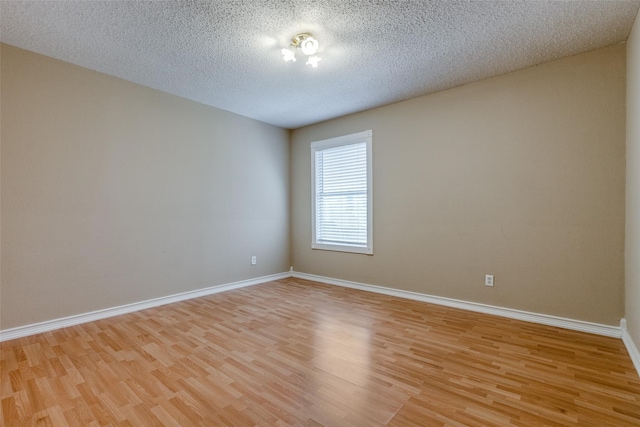 unfurnished room featuring light hardwood / wood-style floors and a textured ceiling