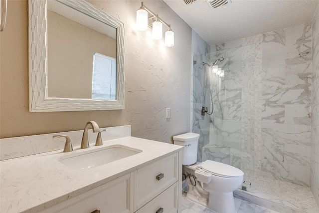 bathroom featuring a tile shower, vanity, and toilet