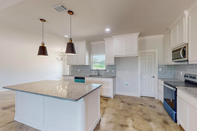 kitchen featuring hanging light fixtures, a kitchen island, appliances with stainless steel finishes, white cabinets, and ornamental molding