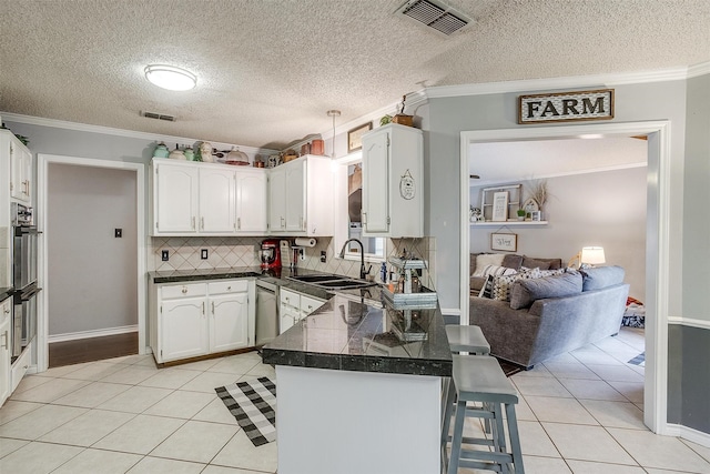 kitchen with sink, light tile patterned floors, kitchen peninsula, crown molding, and white cabinets