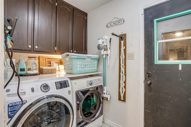 clothes washing area with washer and clothes dryer, cabinets, and a textured ceiling