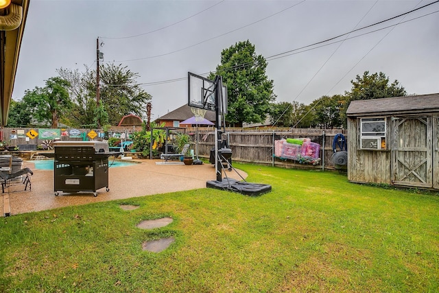 view of yard featuring a patio, a fenced in pool, and a shed