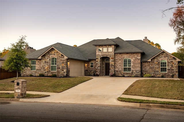 view of front facade with a yard and a garage