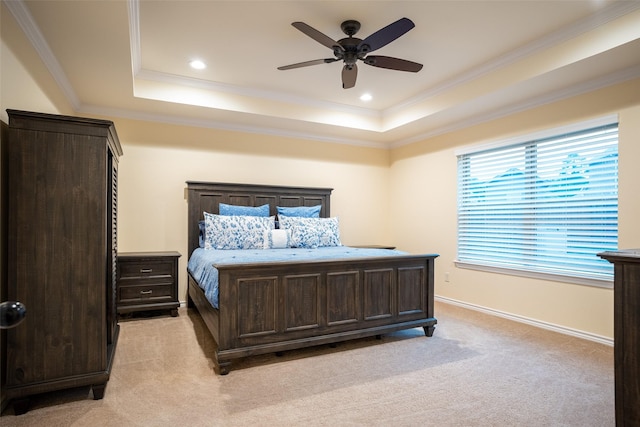carpeted bedroom with ceiling fan, ornamental molding, and a raised ceiling