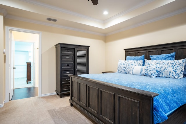 carpeted bedroom with a tray ceiling, crown molding, and ceiling fan