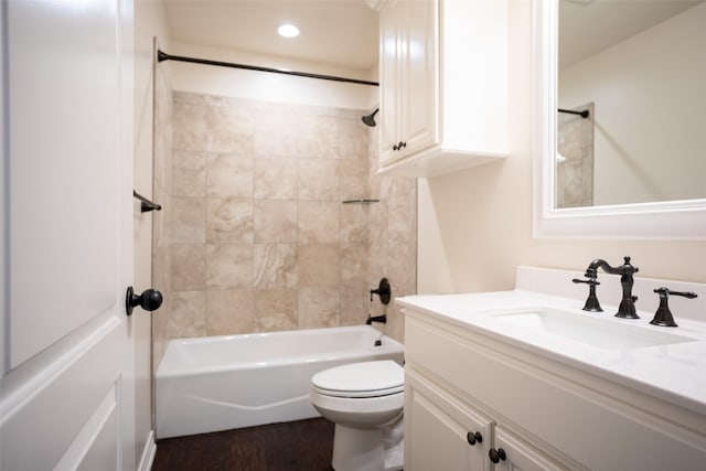 full bathroom featuring tiled shower / bath combo, vanity, wood-type flooring, and toilet
