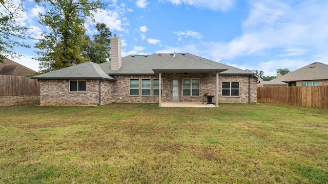 rear view of property with a yard and a patio area