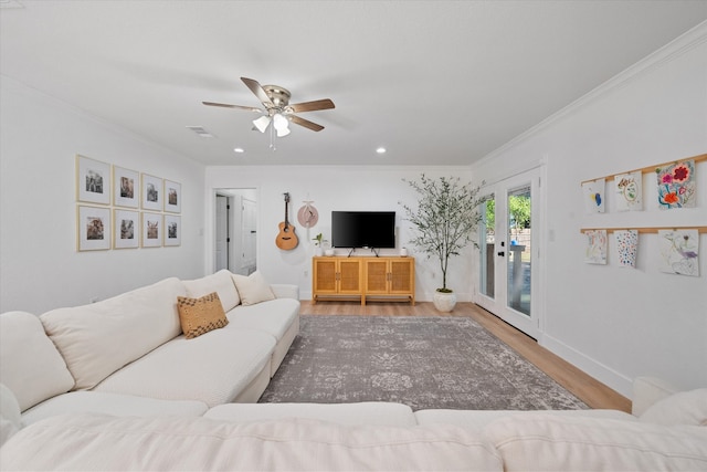 living room featuring crown molding, light hardwood / wood-style floors, french doors, and ceiling fan