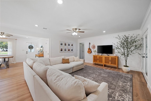 living room with ceiling fan, ornamental molding, and hardwood / wood-style floors