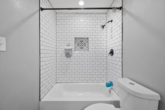 bathroom with tiled shower / bath combo and toilet